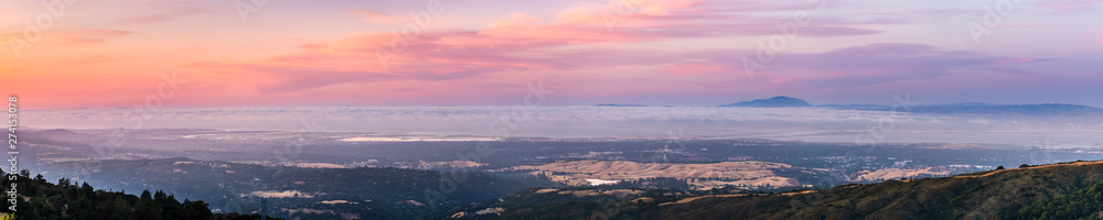 Panoramic view of Silicon Valley and the San Francisco bay area at sunset; Stanford University, Menlo Park, Mountain View, Redwood City, Foster City and Palo Alto visible under a layer of clouds