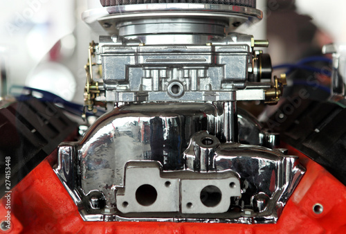 Exhaust manifold and carburetor on a brand new engine in an auto supply shop.
