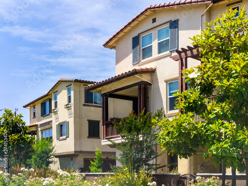 Exterior view of residential building surrounded by trees and hedges; Sunnyvale, San Francisco bay area, California