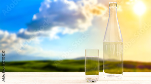 Bottle and glass with fresh cool water on the background of nature  mountains at sunset.