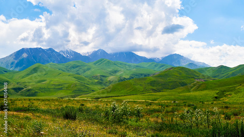 Panorama of a mountain valley in the summer. Fabulous view of the mountain green ridge and the field in front of him, amazing nature, summer in the mountains. Travel and camping, tourism © Юрий Кузнецов