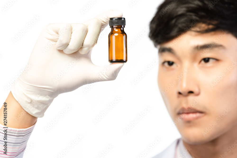 Asian scientist hand holding empty small brown medicine bottle . Asian scientist hand holding empty small brown medicine bottle .