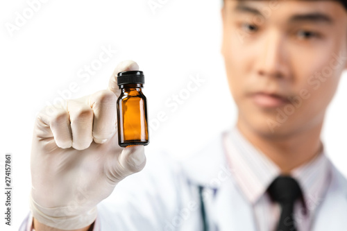 Asian scientist hand holding empty small brown medicine bottle .