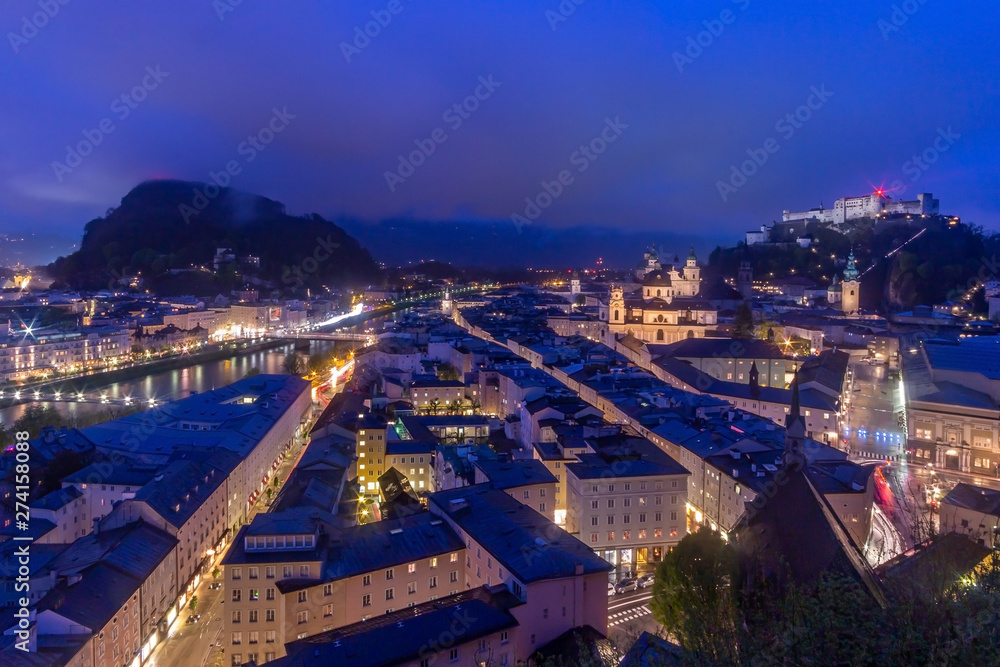 Beautiful view of Salzburg skyline with Festung Hohensalzburg and Salzach river at blue hour, Salzburger Land, Austria
