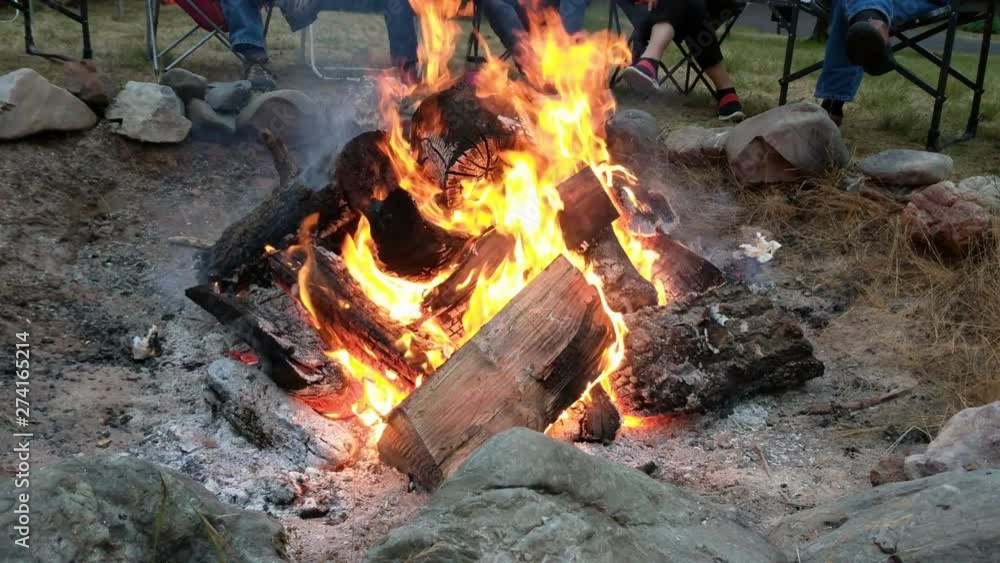 People sitting around camp fire in 4k