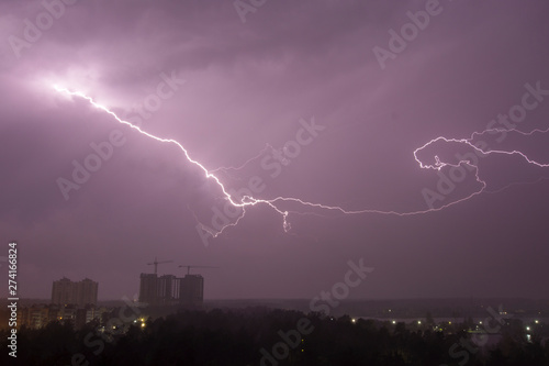 Lightning strike over city in night. Thunderstorm