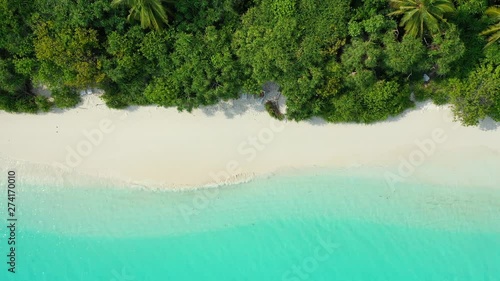 top down tropical island shot of white sand beach coast near crystal transparent ocean water drone arerial shot thailand photo