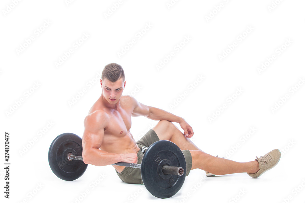 Muscular man working out in studio doing exercises with barbell at biceps, strong male naked torso abs. Isolated on white background. Copy Space. Rest, Sits on the floor at the barbell. Fatigue. Muscular man working out in studio doing exercises with barbell at biceps, strong male naked torso abs. Isolated on white background. Copy Space. Rest, Sits on the floor at the barbell. Fatigue.
