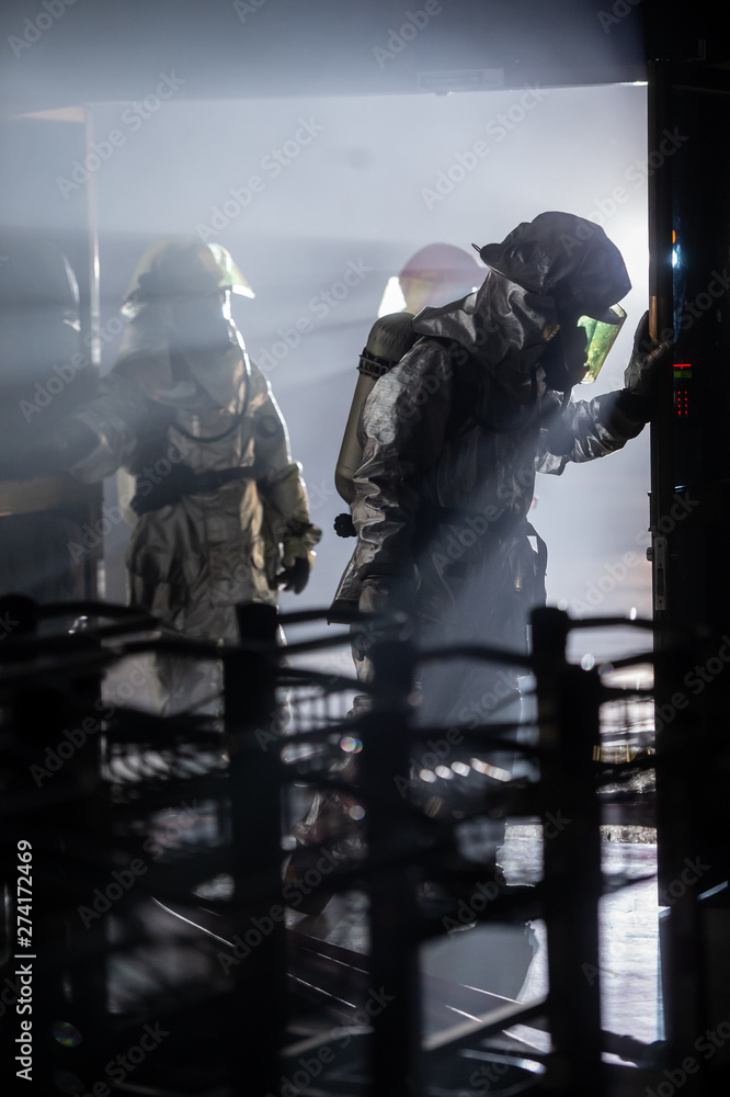 firefighters in silver suit operating on airport site at night. firefighters in silver suit operating on airport site at night.