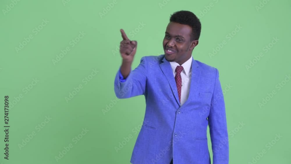 Happy young African businessman pointing finger Happy young African businessman pointing finger