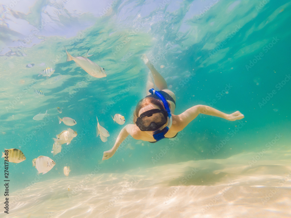 Happy woman in snorkeling mask dive underwater with tropical fishes in coral reef sea pool. Travel lifestyle, water sport outdoor adventure, swimming lessons on summer beach holiday