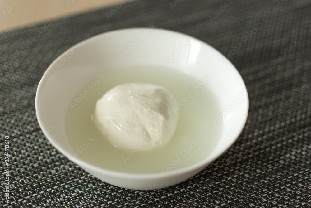 Mozzarella cheese in a bowl with brine. Tasty mozzarella cheese ball. Italian cuisine . Mozzarella cheese in a bowl with brine. Tasty mozzarella cheese ball. Italian cuisine .
