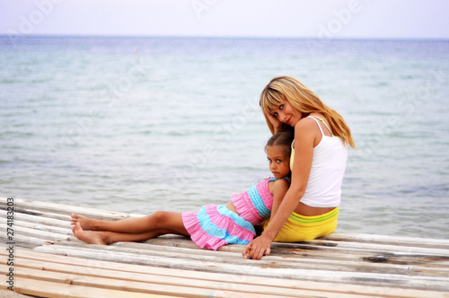 Mom and daughter in the summer. Relax on the beach. Mother and daughter are resting near the sea. Family in the summer on the beach by the ocean