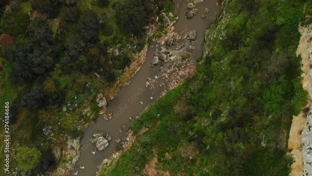 The beautiful valley of Matera with a stream - aerial bird eye view shot The beautiful valley of Matera with a stream - aerial bird eye view shot