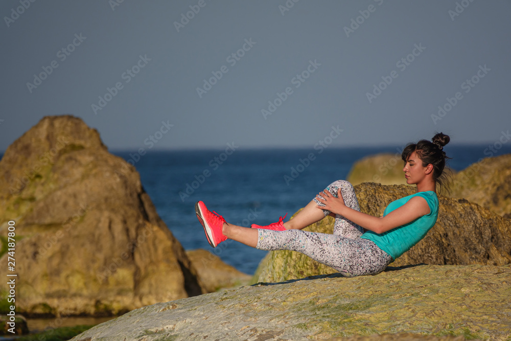 young woman doing exercises in the beach