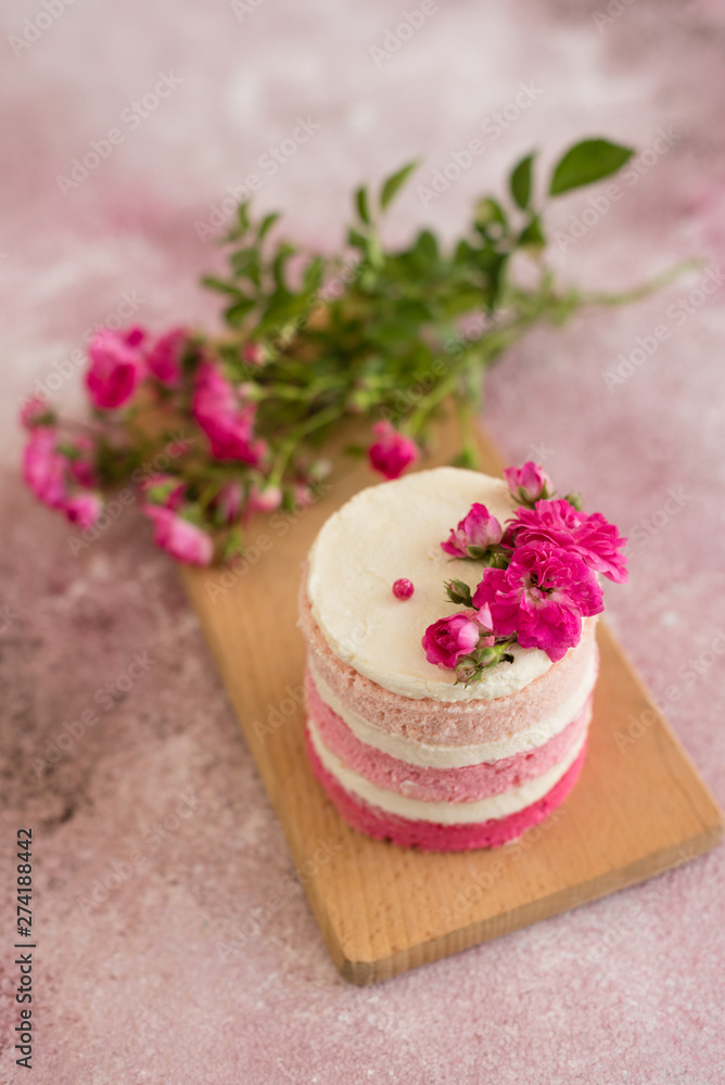 Beautiful pink cream and berries cake on a light concrete background. Birthday celebration Beautiful pink cream and berries cake on a light concrete background. Birthday celebration