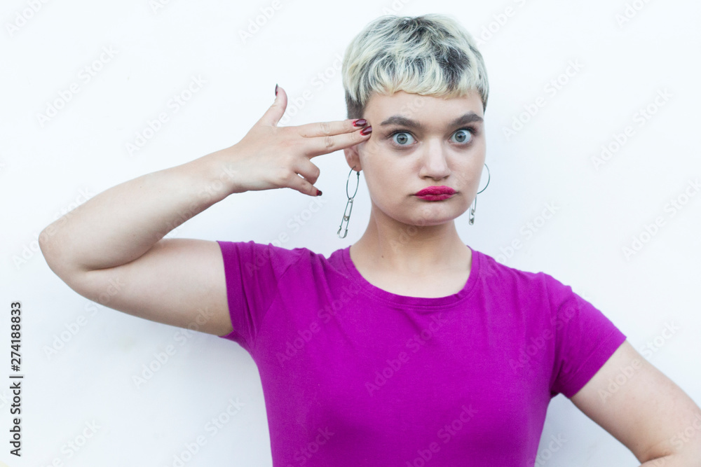 Young blond woman doing ok sign with fingers, showing hush sign with serious expression,showing stop gesture, excellent symbol, isolated over white background Young blond woman doing ok sign with fingers, showing hush sign with serious expression,showing stop gesture, excellent symbol, isolated over white background