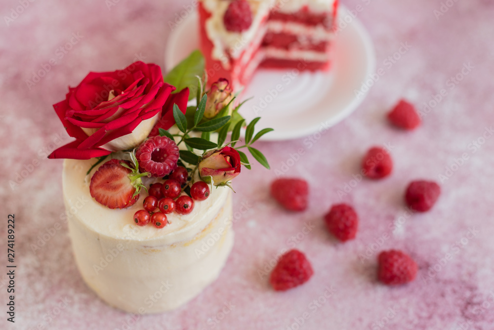 Beautiful pink cream and berries cake on a light concrete background. Birthday celebration