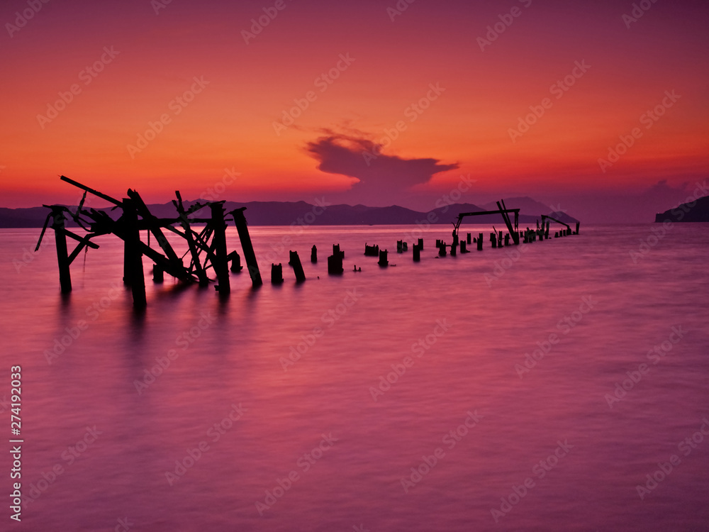 Ruined pier into the sea, idyllic sunset.