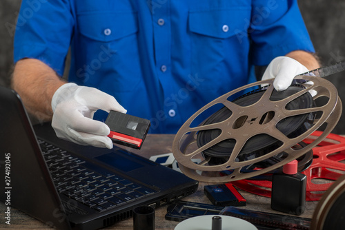 technician with white gloves digitizing old film 16mm and DV photo