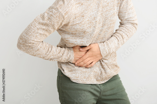 Man suffering from pain in side on white background photo