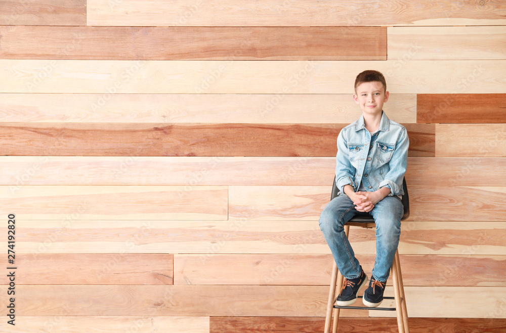 Stylish boy in jeans clothes near wooden wall Stylish boy in jeans clothes near wooden wall