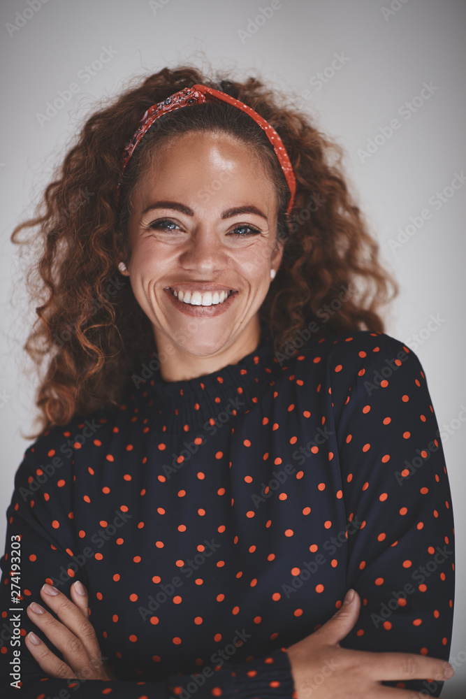 Smiling female entrepreneur standing against a gray background Smiling female entrepreneur standing against a gray background