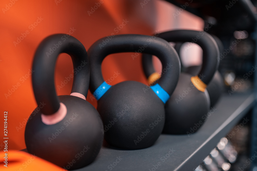 Different kettlebells lying on shelf in the fitness center Different kettlebells lying on shelf in the fitness center