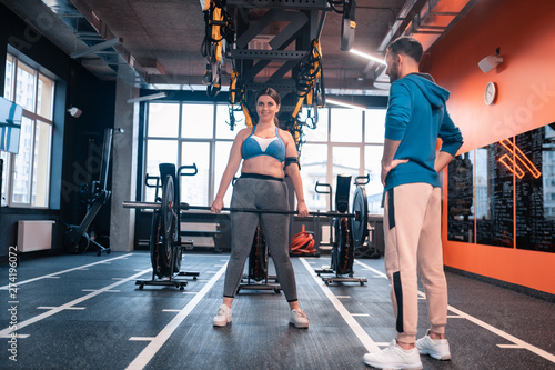 Overweight woman holding barbell while working out