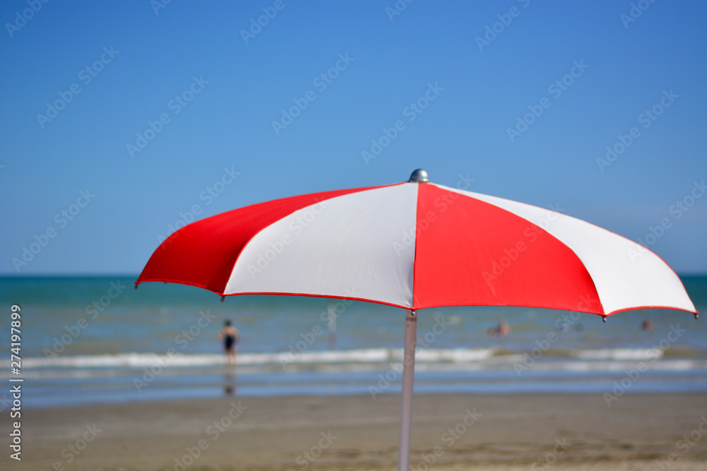 a beach umbrella in front of the sea