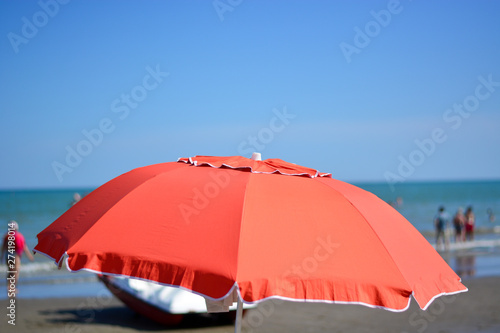 A red umbrella in front of the sea