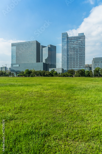 beautiful green meadow near modern office building.