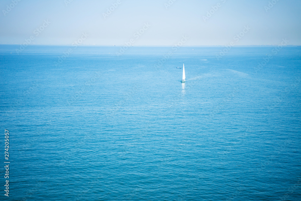 sailboat is sailing in the clear blue sea on a clear day.