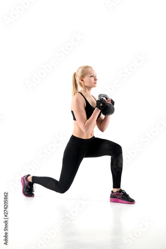 The athlete performs an exercise lunges with a weight in her hands.