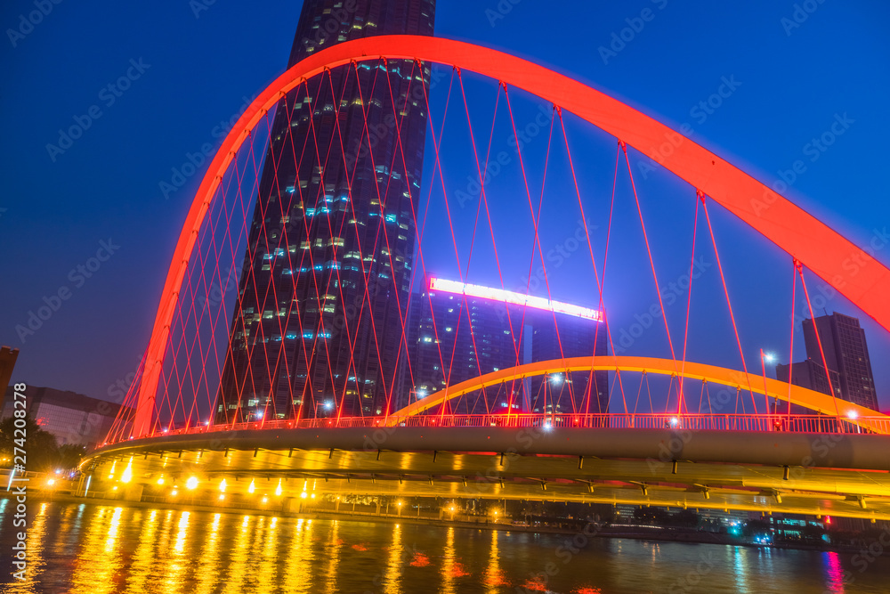 Tianjin Hai river waterfront downtown skyline with illuminated Dagu bridge,China.