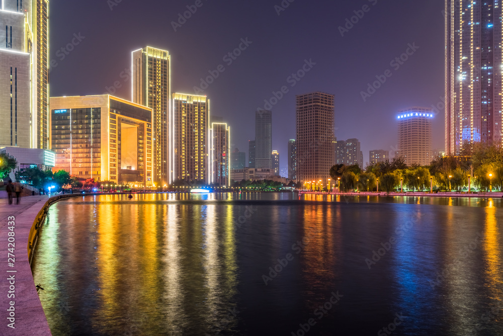 Obraz premium illuminated city waterfront downtown skyline with Haihe river,Tianjin,China.