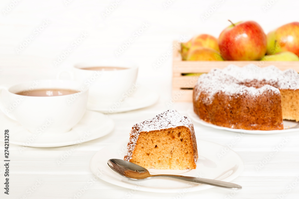 Morning still life with cake with icing served tea and raw apples on white table. Selected focus Morning still life with cake with icing served tea and raw apples on white table. Selected focus