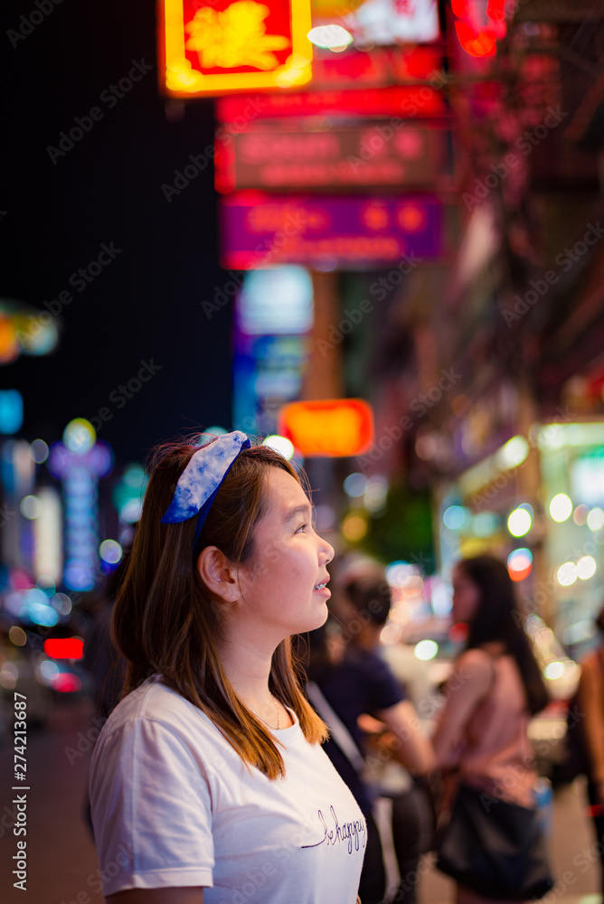 Asian young woman travel in China town at Thailand at Night,Woman travel and eating Night street food market at Yaowarat road, China town Bangkok, Thailand 
