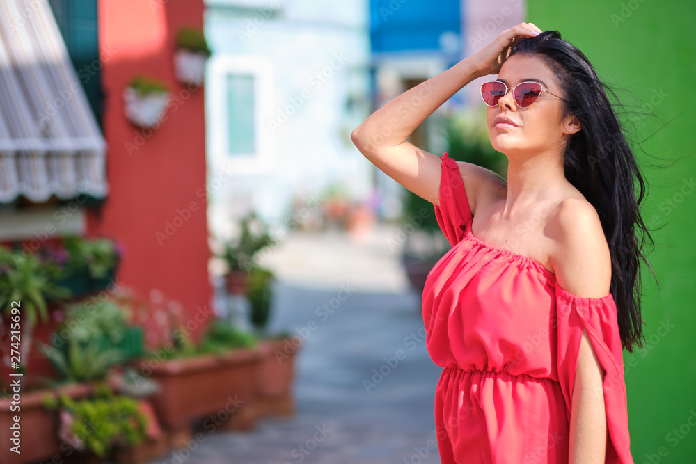 tourist woman posing among colorful houses on Burano island, Venice. Tourism in Italy concept