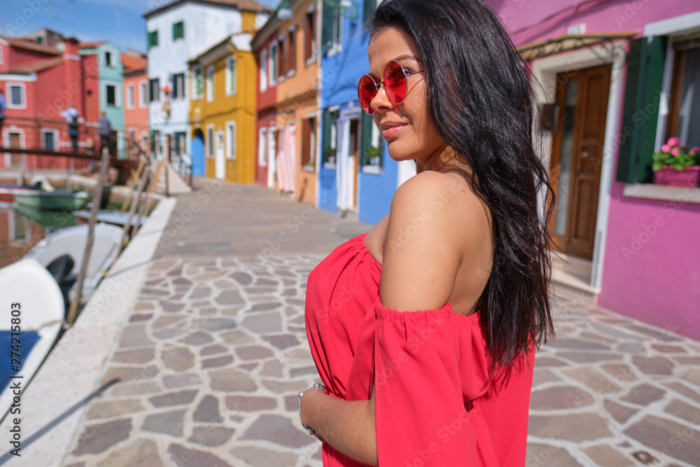 tourist woman posing among colorful houses on Burano island, Venice. Tourism in Italy concept