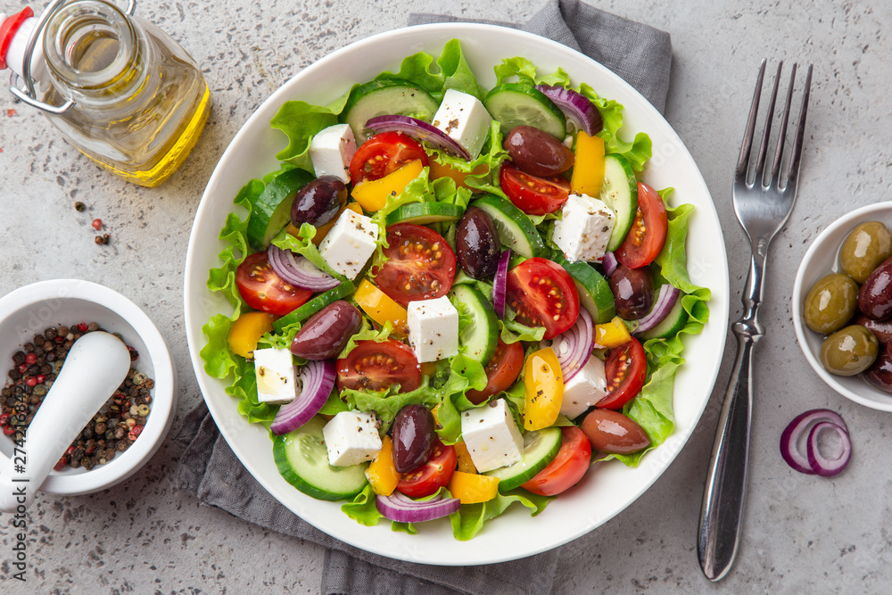 fresh greek salad ( tomato, cucumber, bel pepper, olives  and feta cheese) in white bowl