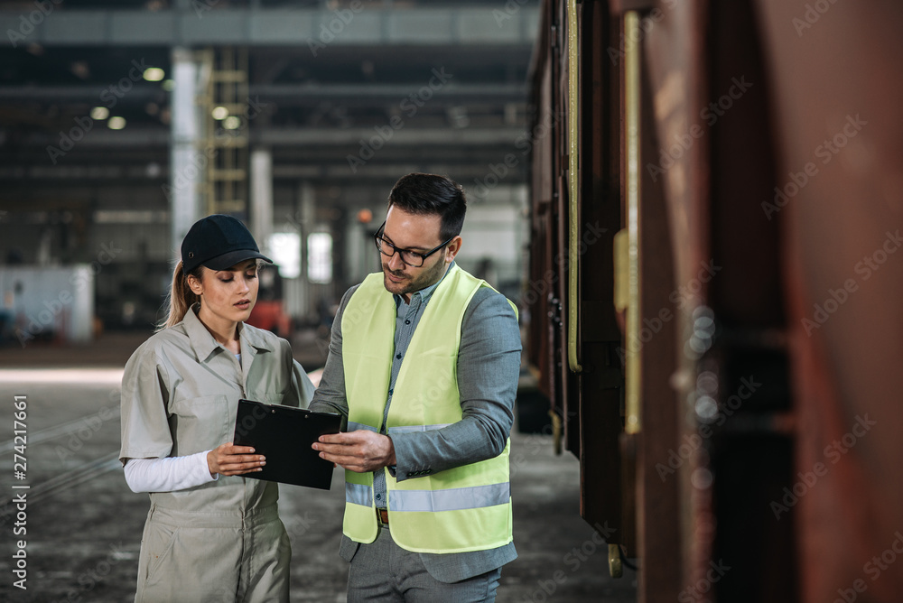 Businessman having a discussion with female team leader in metal industry. Businessman having a discussion with female team leader in metal industry.