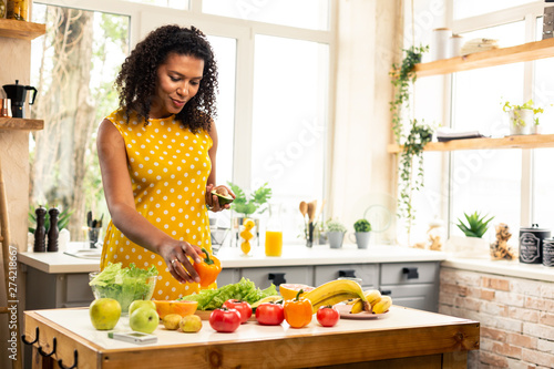 Pregnant woman choosing vegetables for her salad.