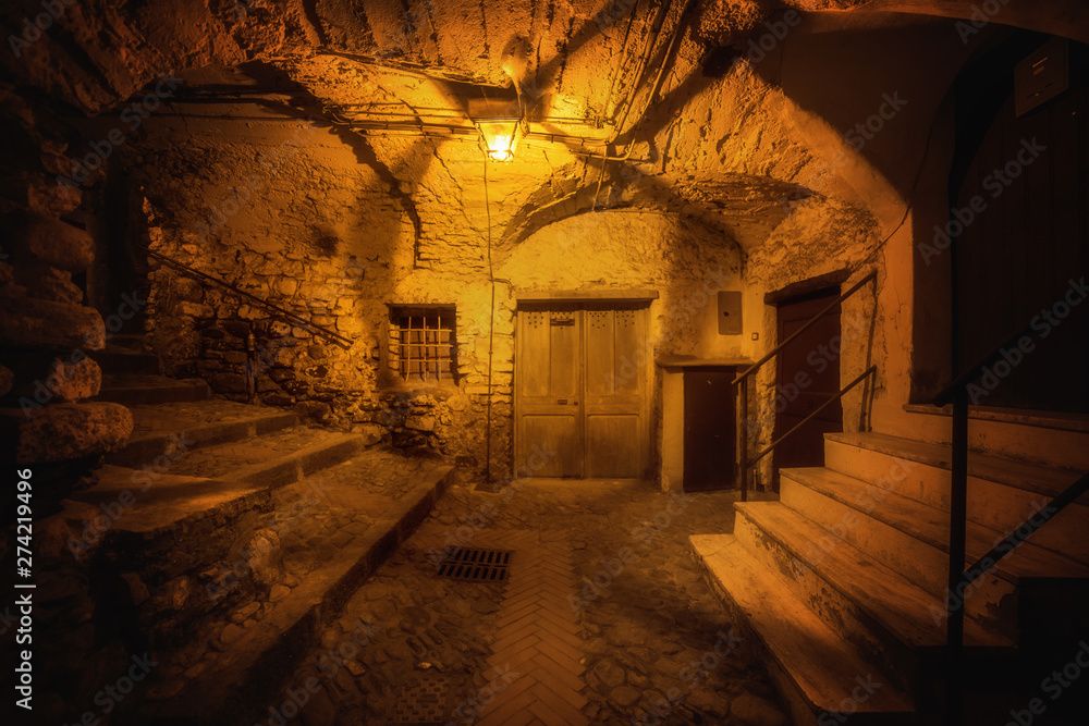 Subterranean street in the night and cozy countryard in the old town of Dolceacqua, Liguria region, Italy