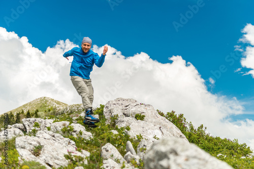 Male hiker jumping on a rocky mountain