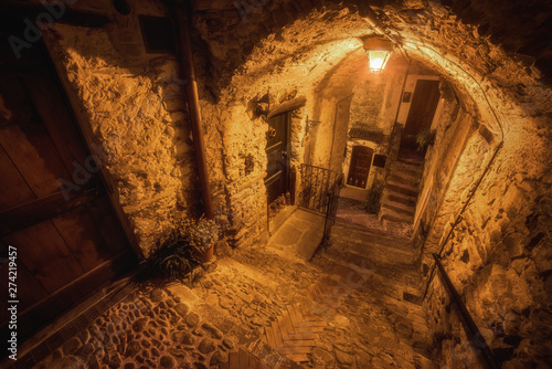 Subterranean street in the night and cozy countryard in the old town of Dolceacqua, Liguria region, Italy photo