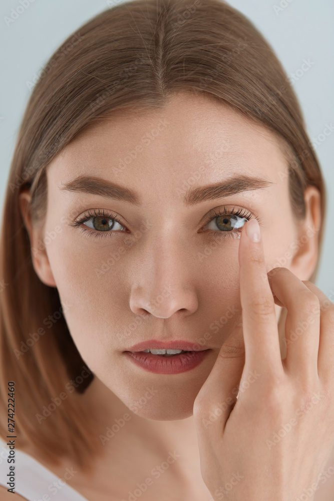 Contact eye lens. Woman applying eye contacts on eyes closeup