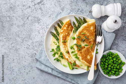 omelette with asparagus and green peas on white plate