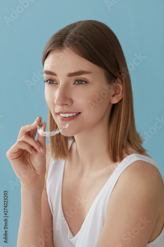 Teeth whitening. Woman with healthy teeth using removable braces