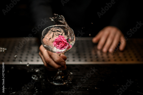 Close shot of bartender with cocktail with flower